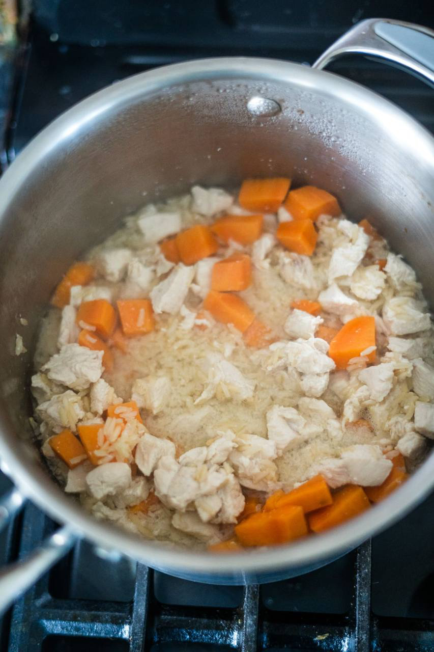 Chicken and carrots cooking in a pot